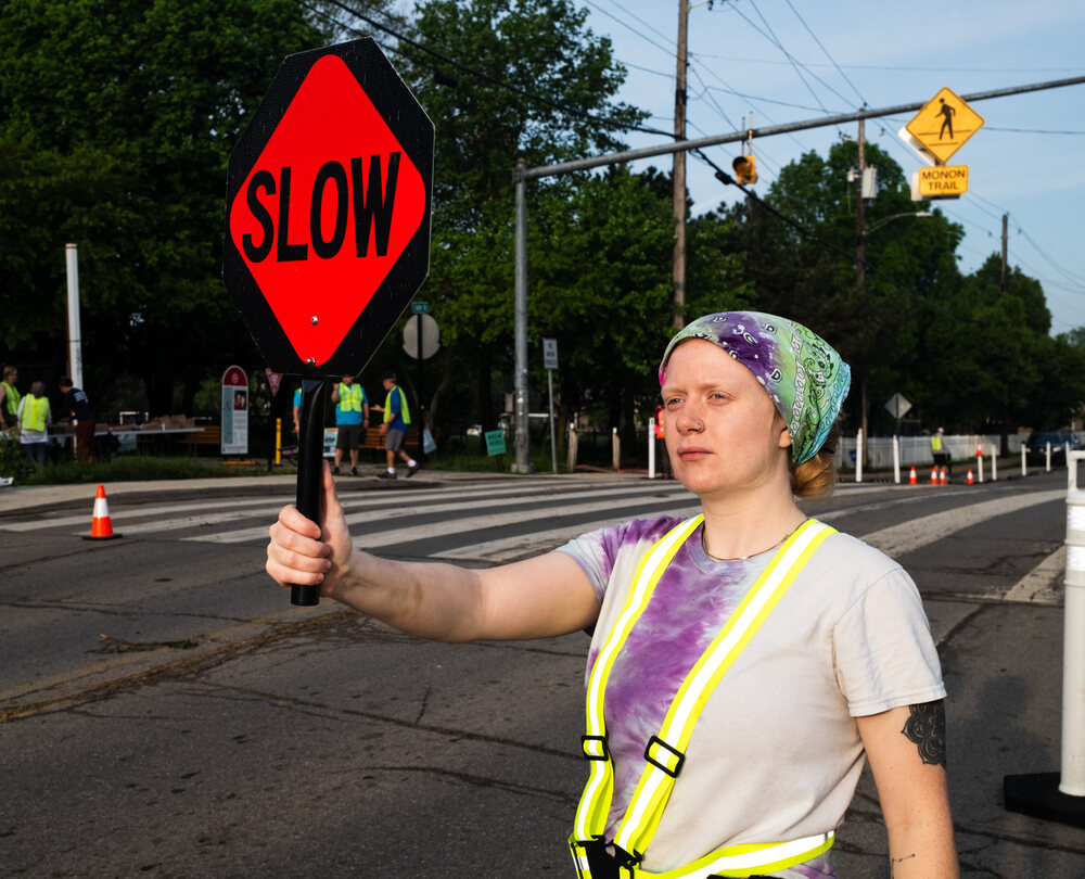A neighbor holding a slow sign at the 16th and Monon crossing